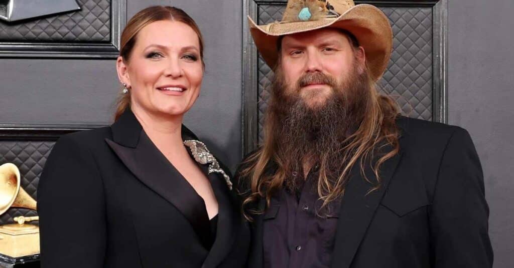 hris Stapleton and his wife pose together, both wearing cowboy hats, capturing a moment of joy in a photograph.