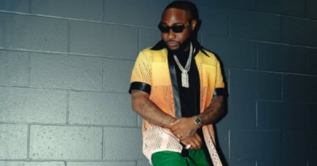 Davido, in a yellow shirt and green pants, presents a colorful and fashionable appearance.