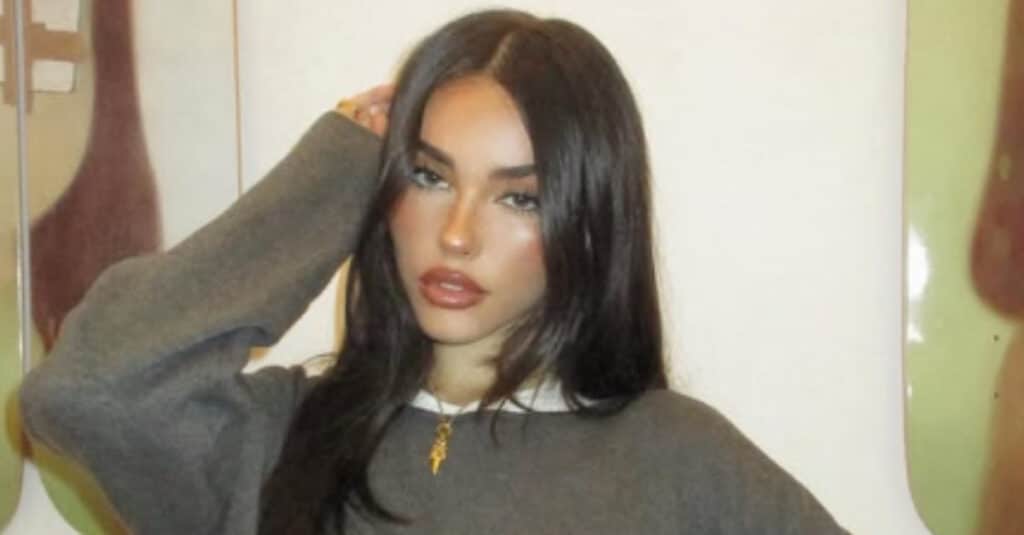 Madison Beer, a woman with long hair, dressed in a fashionable sweater, exuding a casual yet chic vibe.