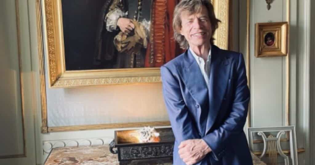 Mick Jagger pose  at the Louvre, showcasing his  stylish presence in the iconic museum.